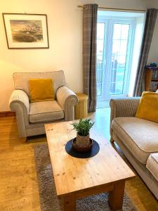 a living room with two couches and a coffee table at 5 Glantraeth Farm Cottage in Bodorgan