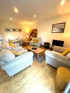 a living room with two couches and a table at 5 Glantraeth Farm Cottage in Bodorgan