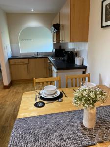 a kitchen with a wooden table with plates and dishes on it at 5 Glantraeth Farm Cottage in Bodorgan