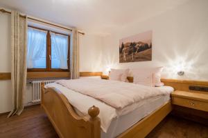 ein Schlafzimmer mit einem großen Bett und einem Fenster in der Unterkunft Landhaus Kopp in Oberstdorf