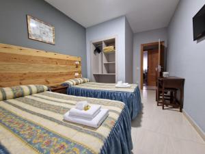 A bed or beds in a room at Hostal Soto