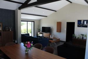 uma sala de estar com uma mesa e um sofá azul em Villa grand standing avec piscine proche Nantes em La Chapelle-Heulin