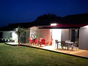 eine Terrasse mit roten Stühlen und einem Tisch darauf in der Unterkunft Villa grand standing avec piscine proche Nantes in La Chapelle-Heulin