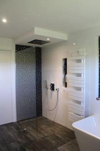 a bathroom with a shower and a tub and a sink at Villa grand standing avec piscine proche Nantes in La Chapelle-Heulin