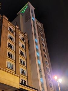 a tall building with a clock tower at night at The Viana Apartment 3 in Kota Bharu