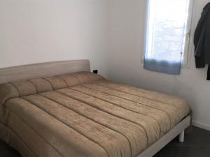 a bed in a small room with a window at Silvia al mare in Diano Marina +15 photos