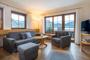 ein Wohnzimmer mit einem Sofa, 2 Stühlen und einem TV in der Unterkunft Landhaus Kopp in Oberstdorf