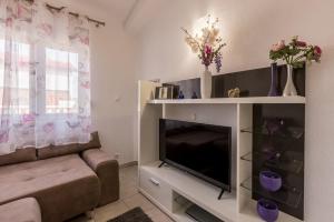 een woonkamer met een televisie en een bank bij Holiday Home Little Desire - Sevid in Sevid