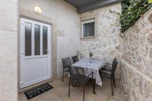 een patio met een tafel en stoelen en een witte deur bij Holiday Home Little Desire - Sevid in Sevid