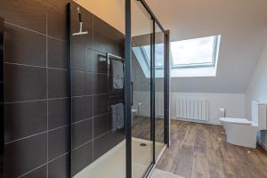 uma casa de banho com uma cabina de duche em vidro e um WC. em Gîte Serenida em Criquebeuf-sur-Seine