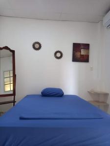 1 dormitorio con 1 cama azul y 2 relojes en la pared en DEPARTAMENTO-MANTA, Playa Murciélago, en Manta