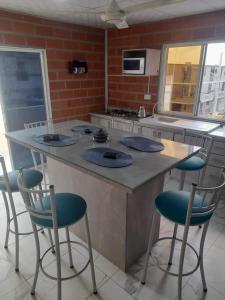 a kitchen with a large island with blue chairs at DEPARTAMENTO-MANTA, Playa Murciélago in Manta