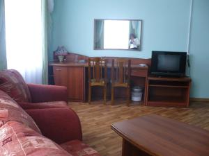 sala de estar con sofá y escritorio con TV en Siyaniye Severa Hotel en Vel'sk