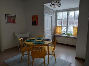 een eetkamer met een tafel en stoelen en een raam bij Nostalgista majoittumista Taiteilijatalo Taideniityn Auringossa tai Niityssä in Varkaus