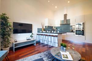 un soggiorno con cucina e tavolo di Kensington - Lexham Gardens by Viridian Apartments a Londra