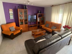 a living room with a couch and chairs and a tv at Apartamento - La Cala in Cala del Moral