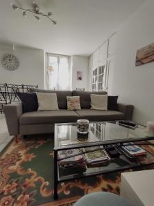 uma sala de estar com um sofá e uma mesa de centro em Chez Lucia appartement climatisé em Périgueux