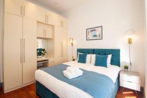 a bedroom with a blue and white bed with towels on it at Kensington - Lexham Gardens by Viridian Apartments in London