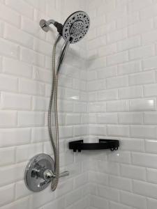 a shower with a shower head in a bathroom at Relax in Style at Our 3BR 2BA Retreat with Private Pool, Game Room, Fire Pit, Yoga in Tampa