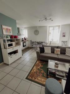 uma sala de estar com um sofá e uma cozinha em Chez Lucia appartement climatisé em Périgueux