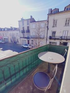 uma mesa e duas cadeiras numa varanda em Chez Lucia appartement climatisé em Périgueux