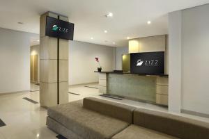 a lobby with a couch and a tv on a wall at Zizz Convention Hotel in Denpasar
