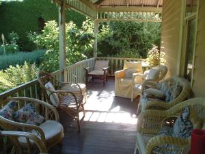 eine Veranda mit Sofas und Stühlen auf einem Haus in der Unterkunft Mooltan House in Hepburn Springs