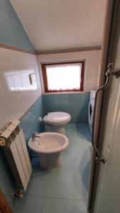a small bathroom with a toilet and a sink at Appartamento Bucaneve in Ovindoli