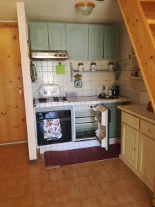 a kitchen with green cabinets and a stove at Appartamento Bucaneve in Ovindoli