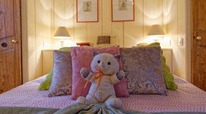 ein ausgestopfter Teddybär auf einem Bett in der Unterkunft Remparts de Riquewihr - Refuge du Lutin - Studio in Riquewihr