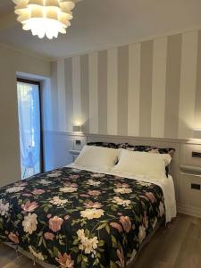 a bedroom with a large bed with a floral blanket at Atelier Fuori Città in Perugia