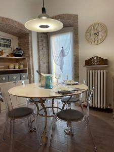 a dining room with a table and chairs and a clock at Atelier Fuori Città in Perugia