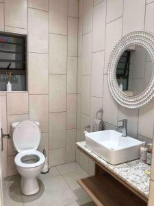 La salle de bains est pourvue de toilettes, d'un lavabo et d'un miroir. dans l'établissement Bella Casa Villa, à Hartbeespoort