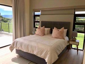 - une chambre avec un grand lit et un balcon dans l'établissement Bella Casa Villa, à Hartbeespoort