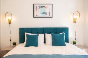 una camera con letto blu e bianco con cuscini di Kensington - Lexham Gardens by Viridian Apartments a Londra