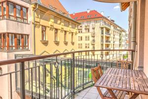 balcón con banco de madera y algunos edificios en City Center Apartments, en Budapest