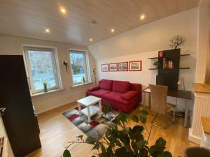 a living room with a red couch and a table at Ferienwohnung Maike in Lübeck