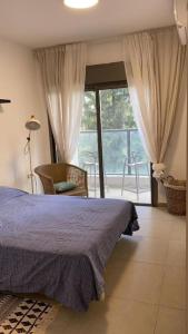 1 dormitorio con cama y ventana grande en Family Apartment By IsrApart, en Ramat Gan