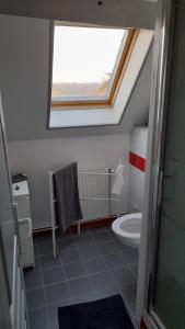 a bathroom with a window and a toilet in it at Chantilly Villa Quincampoix in Chantilly