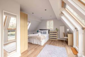 a bedroom with a bed and a desk and windows at Cosy Home Near Sunningdale/Ascot/Wentworth Golf Club in Sunninghill