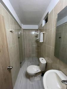 y baño con aseo y lavamanos. en Aparta-hotel laureles 302, en Medellín