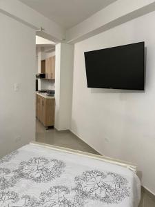 1 dormitorio con 1 cama y TV de pantalla plana en Aparta-hotel laureles 302, en Medellín