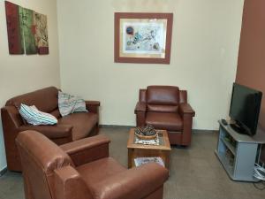ein Wohnzimmer mit Ledermöbeln und einem TV in der Unterkunft Casa residencial en ubicación preferencial Dorrego in Guaymallen