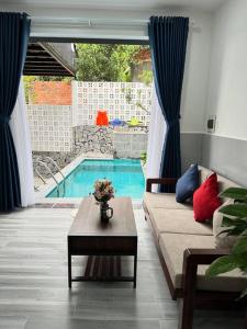 a living room with a couch and a swimming pool at Homestay Luna mountain & sea views! in Vung Tau