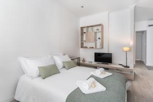 um quarto com uma cama branca com duas bandejas em Casa Trindade no Porto