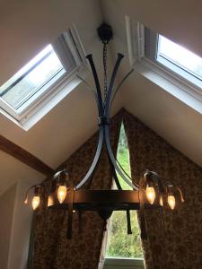 Luxury Exmoor Barn conversion with Sauna في إكسفورد: ثريا معلقة من السقف مع نافذة