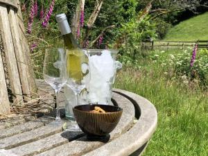 a bottle of wine and two glasses on a table at Peaceful Exmoor Barn conversion with Sauna in Exford