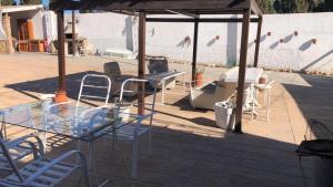 a glass table and chairs under a gazebo at Mirador de Garciez in Torre del Campo