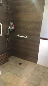 a bathroom with a shower with a wooden wall at Mirador de Garciez in Torre del Campo