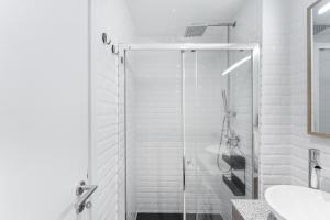 um banheiro branco com chuveiro e pia em Casa Trindade no Porto